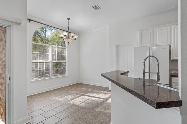 a kitchen with stainless steel appliances granite countertop white cabinets and a refrigerator