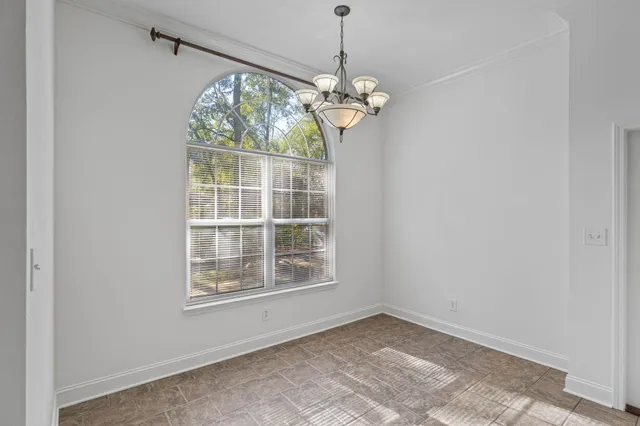 a kitchen with white cabinets sink and window