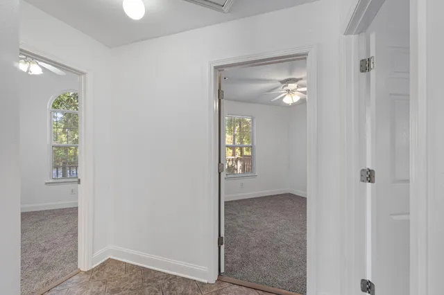 a view of an empty room and chandelier fan