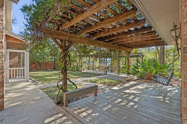 a view of swimming pool with lawn chairs and plants