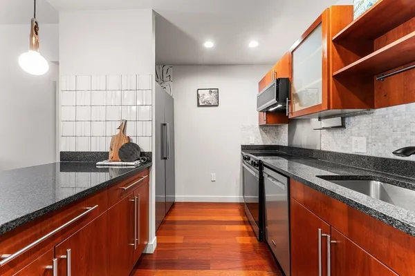 a kitchen with stainless steel appliances granite countertop a sink and a stove