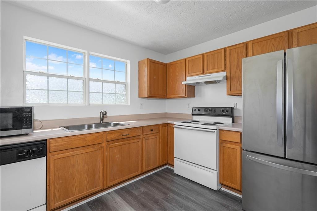 57 Inverness Trace Riverdale, GA 30274 - Photo 11 of 30 a kitchen with stainless steel appliances a sink stove and refrigerator