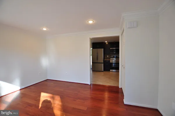 a view of empty room with wooden floor
