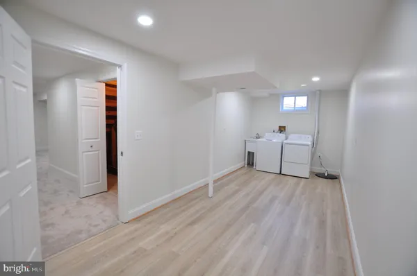 a view of a white house with large trees and a yard