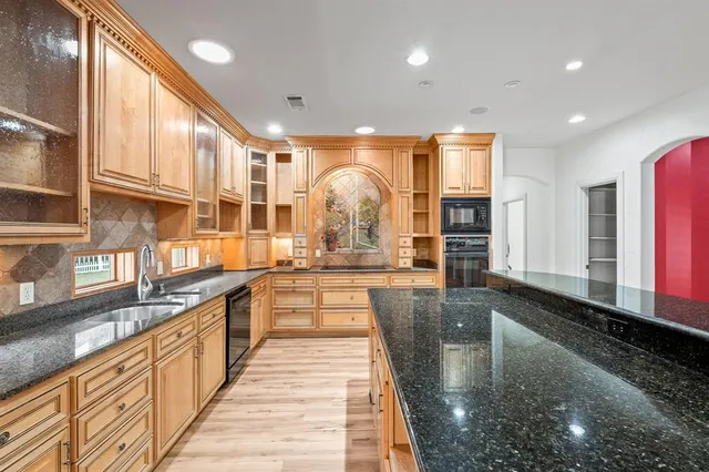 a large kitchen with stainless steel appliances lots of counter space and a sink