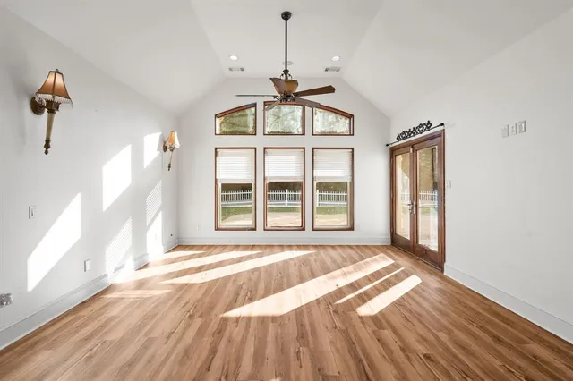 a view of a room with wooden floor chandelier and windows