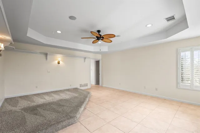 an empty room with window and ceiling fan