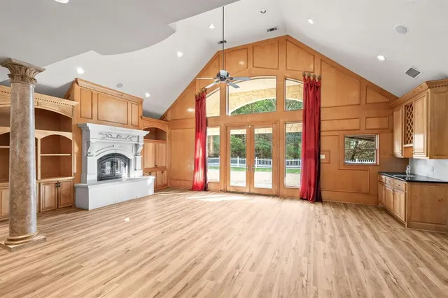 a view of an empty room with a fireplace and a window