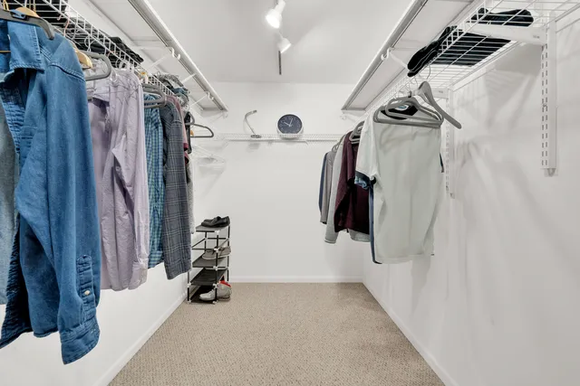 a view of walk in closet with clothes and shoes