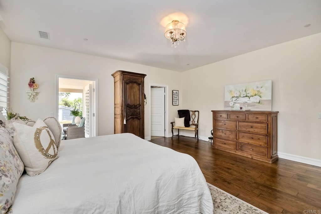 1494 Meredith Road Fallbrook, CA 92028 - Photo 19 of 47 a bedroom with a bed and a chandelier