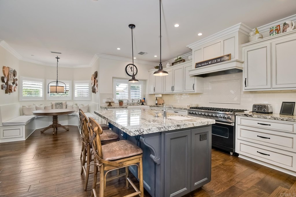 1494 Meredith Road Fallbrook, CA 92028 - Photo 23 of 47 a kitchen with stainless steel appliances granite countertop a stove a sink a oven a dining table and chairs with wooden floor