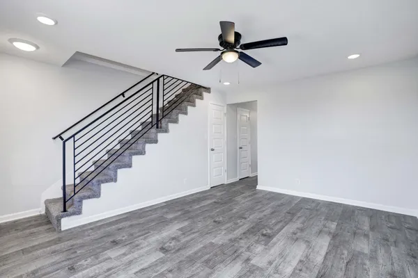a view of a hallway with wooden floor and stairs