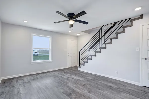 a view of an entryway with wooden floor and a ceiling fan