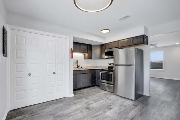 a kitchen with stainless steel appliances a refrigerator and a stove top oven