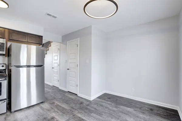 a view of a kitchen with a refrigerator and wooden floor