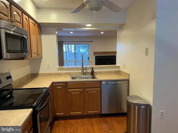 a kitchen with a sink and a stove top oven with wooden floor