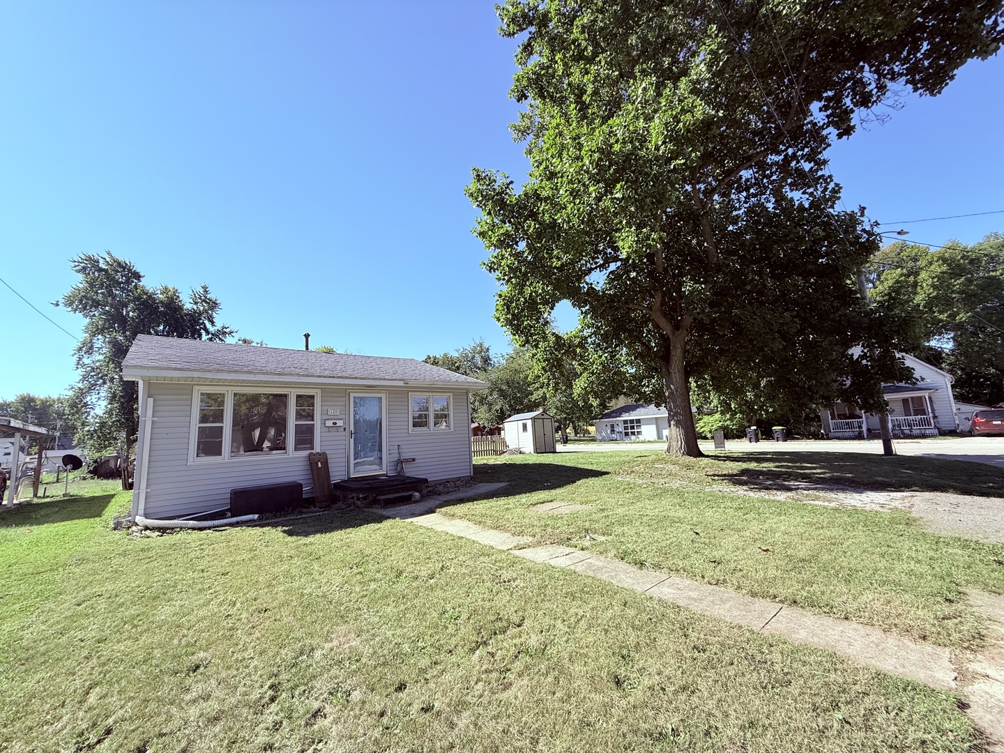 a view of a house with a yard and large trees