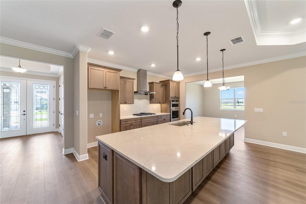 10537 Southwest 96th Lane Road Ocala, FL 34481 - Photo 35 of 75 a kitchen with kitchen island a stove a sink a center island and wooden floor