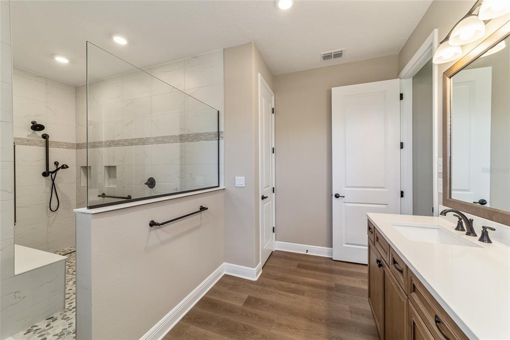 10537 Southwest 96th Lane Road Ocala, FL 34481 - Photo 48 of 75 a bathroom with a sink a mirror and a shower