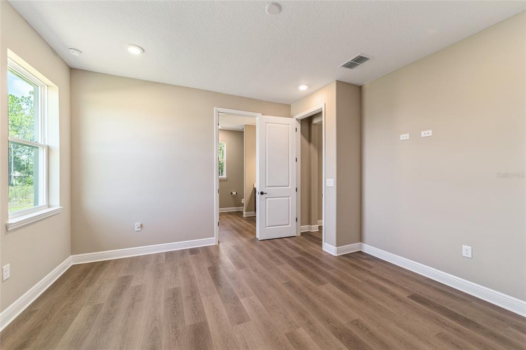 10537 Southwest 96th Lane Road Ocala, FL 34481 - Photo 53 of 75 a view of an empty room with wooden floor and a window