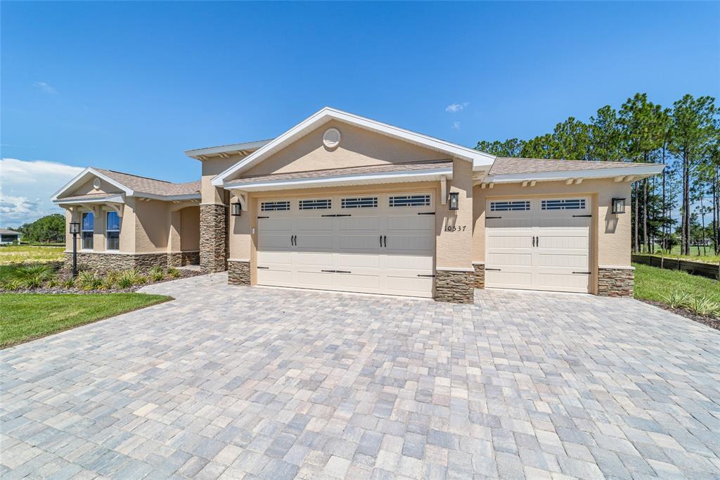 10537 Southwest 96th Lane Road Ocala, FL 34481 - Photo 7 of 75 a front view of a house with a yard and garage
