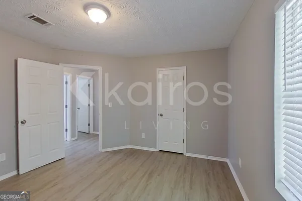 an empty room with wooden floor and windows