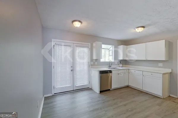 a kitchen with granite countertop white cabinets and white appliances