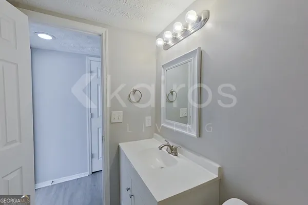 a bathroom with a sink a light fixture and a mirror