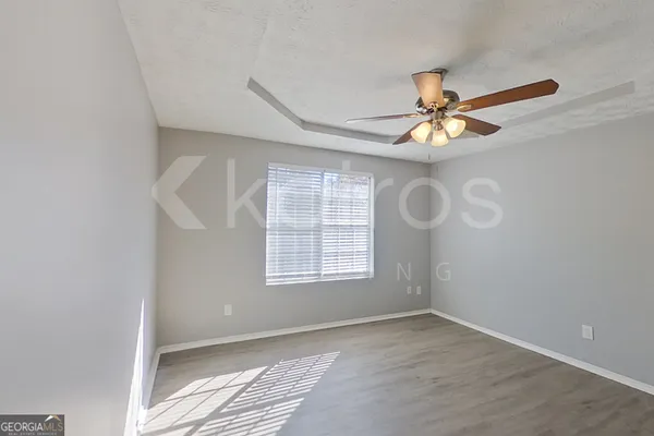 an empty room with a window and a fan
