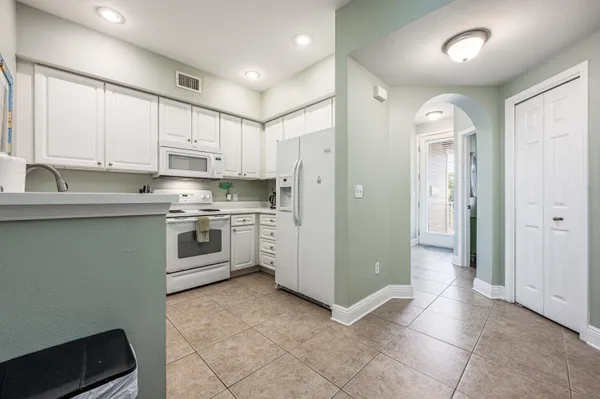 a kitchen with white cabinets and white appliances