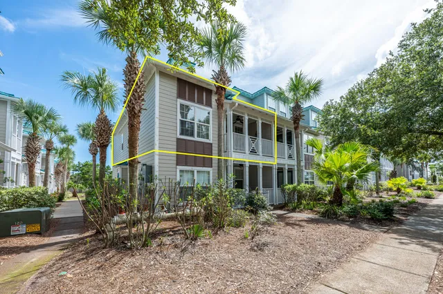 a front view of a house with plants and trees