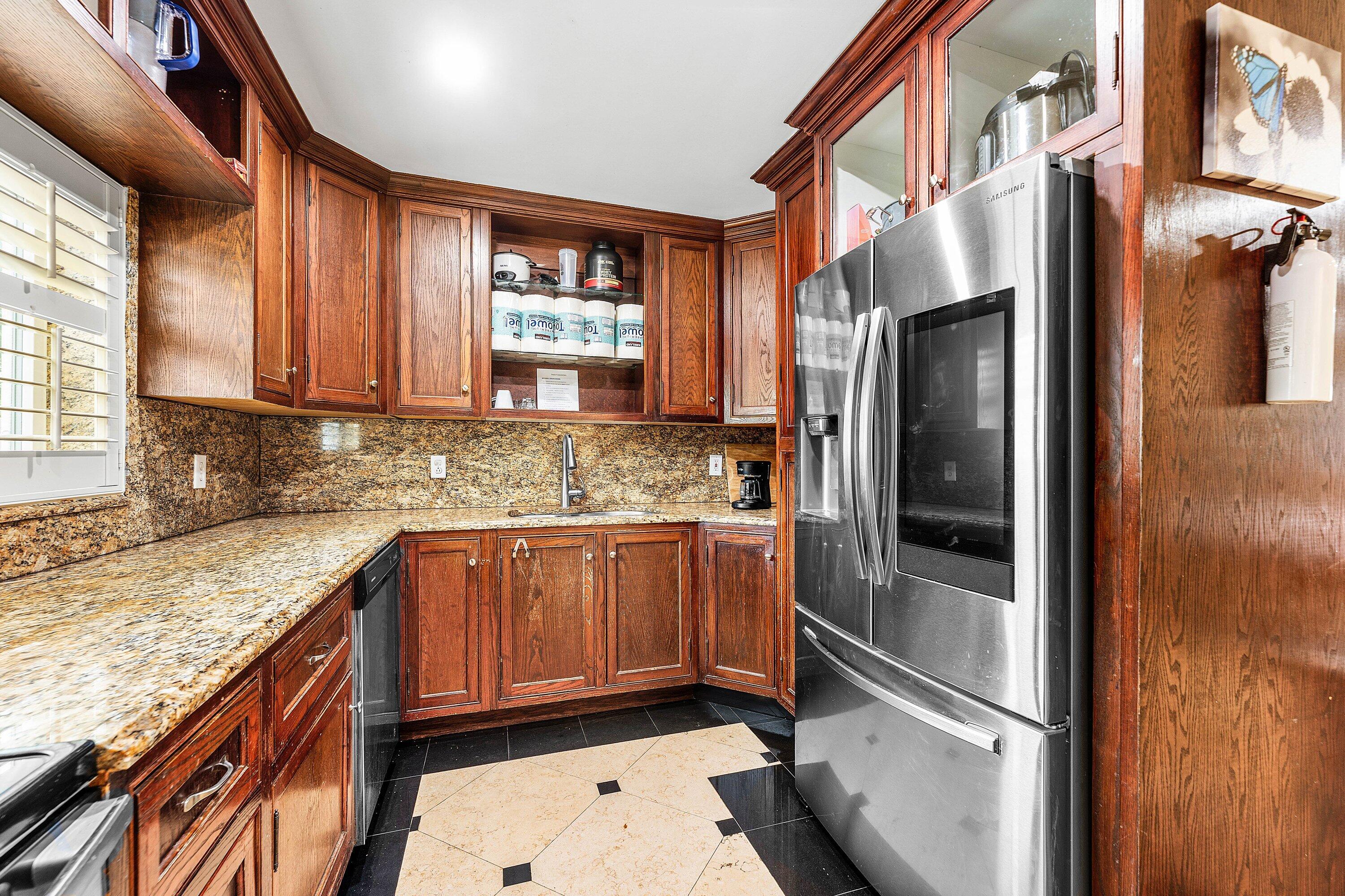 305 Southwest 3rd Street Boynton Beach, FL 33435 - Photo 14 of 36 a kitchen with stainless steel appliances granite countertop a refrigerator a sink and a stove