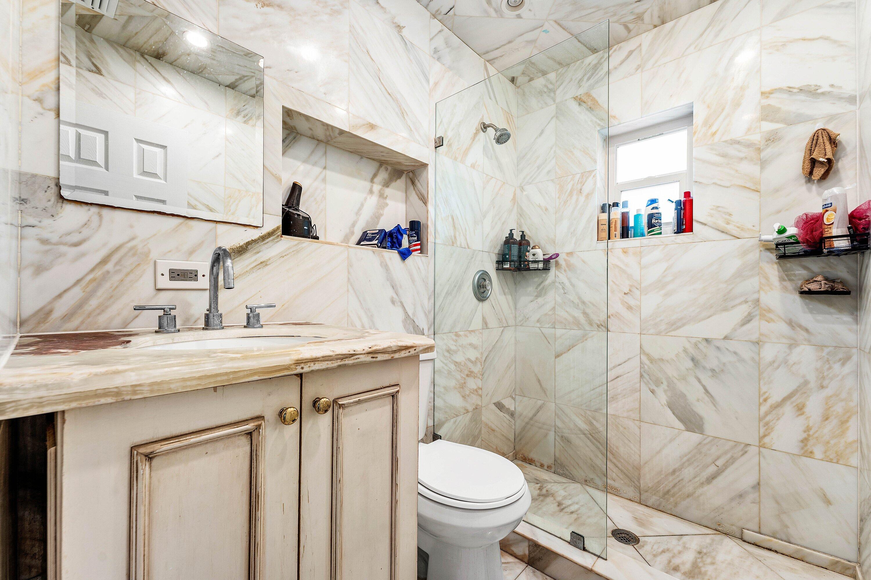 305 Southwest 3rd Street Boynton Beach, FL 33435 - Photo 16 of 36 a bathroom with a sink toilet and a mirror