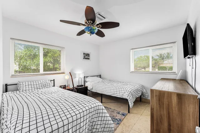 a bedroom with two beds and a flat screen tv