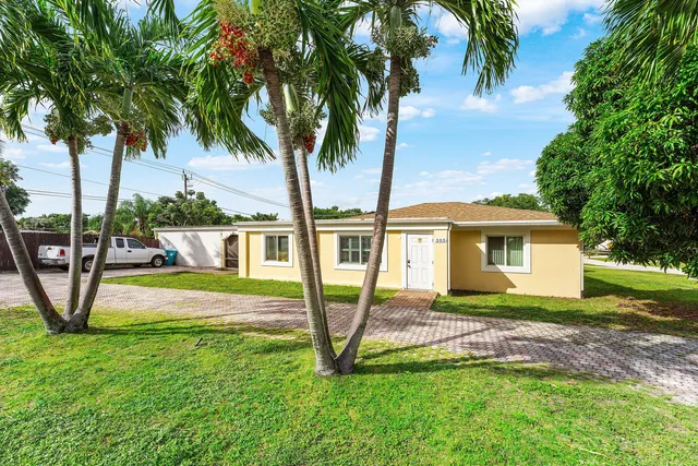 a view of a house with backyard and a tree