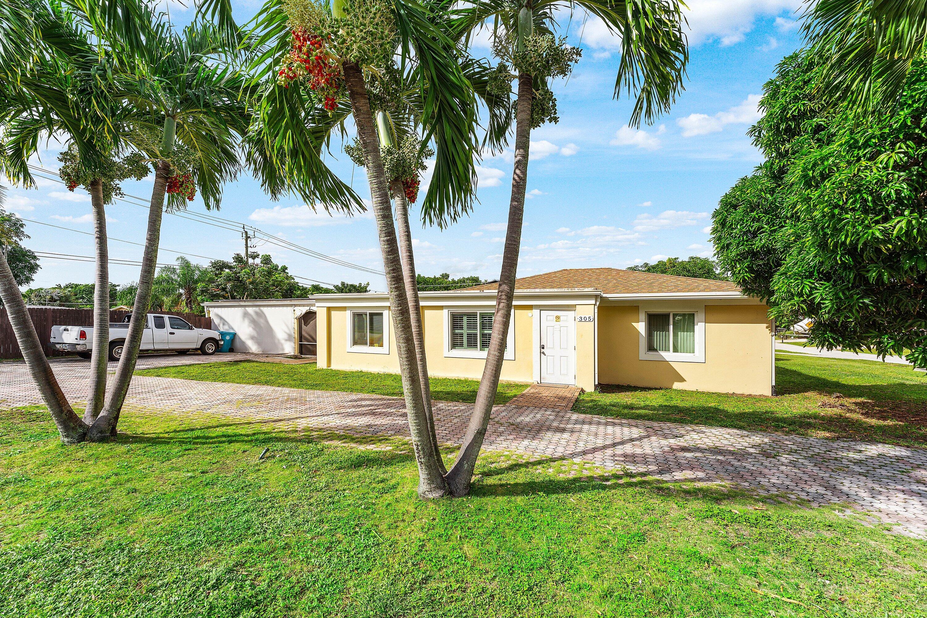305 Southwest 3rd Street Boynton Beach, FL 33435 - Photo 2 of 36 a view of a house with backyard and a tree