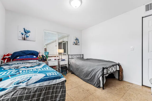 a bedroom with two beds and a chandelier