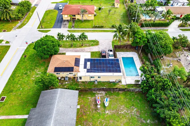 an aerial view of a house with a garden and lake view