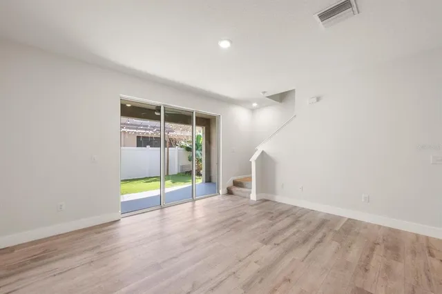 an empty room with floor to ceiling window and an outdoor view