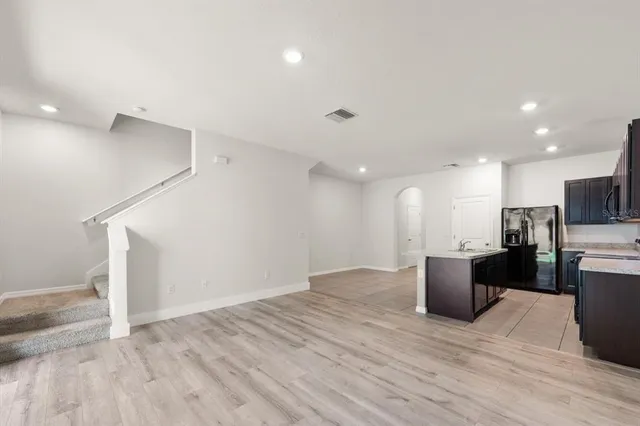 a view of kitchen with stainless steel appliances refrigerator stove microwave and cabinets