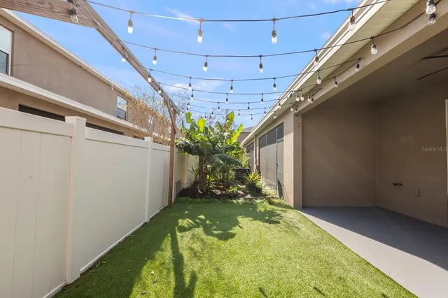 a view of a house with brick walls and a yard with a large tree