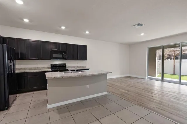 a kitchen with stainless steel appliances granite countertop a stove a sink and a refrigerator