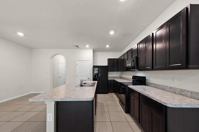 a large kitchen with stainless steel appliances a large counter top