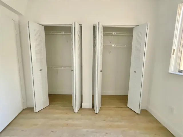 an empty room with windows and closet