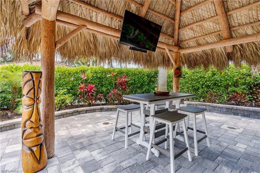 13526 Snook Circle Naples, FL 34114 - Photo 12 of 36 a view of a backyard with table and chairs potted plants