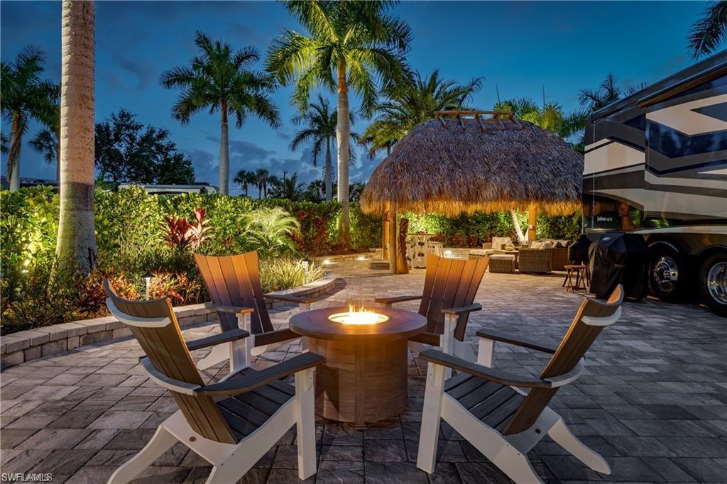 13526 Snook Circle Naples, FL 34114 - Photo 2 of 36 a view of a patio with table and chairs potted plants and palm tree