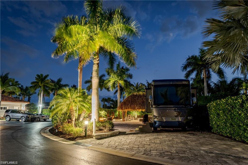 13526 Snook Circle Naples, FL 34114 - Photo 3 of 36 a vase of flowers sitting on a table with potted plants