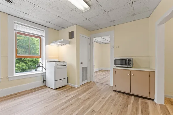a kitchen with a wooden floor and white appliances