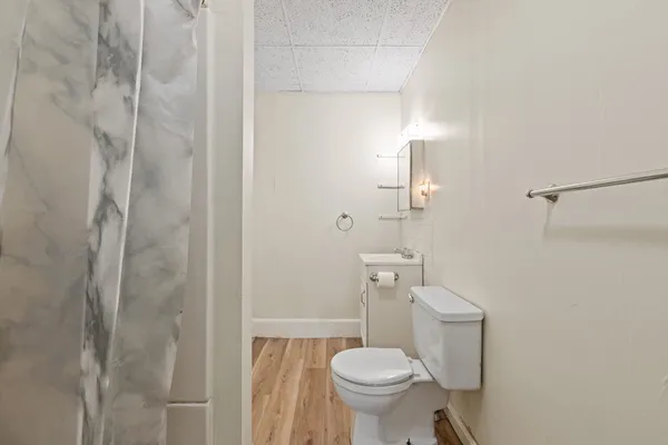 a white toilet sitting next to a shower