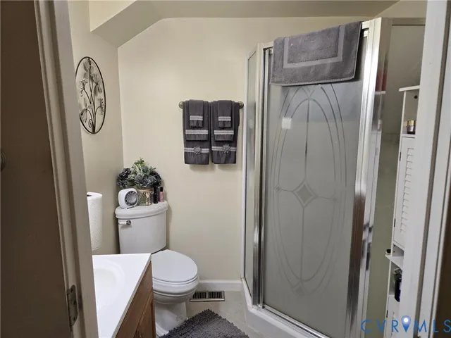 a white toilet sitting next to a bathroom sink and a shower